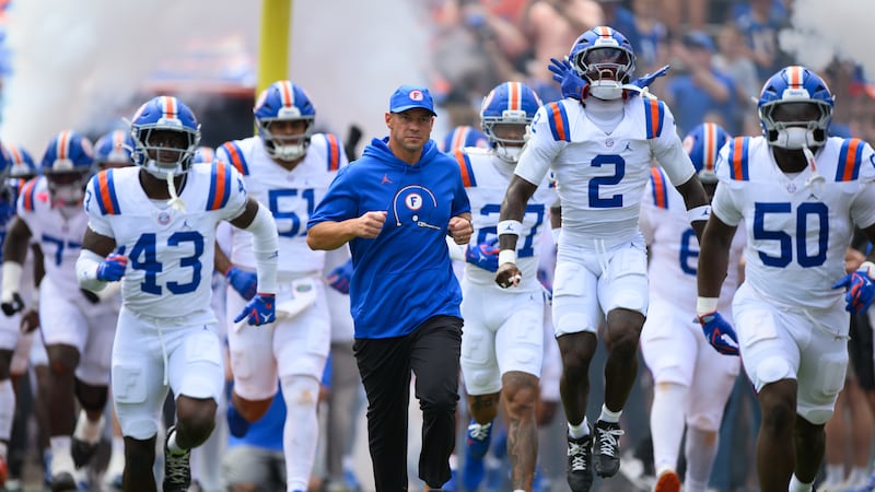 Florida head coach Jon Sumrall leads his team onto the field before an NCAA college football...