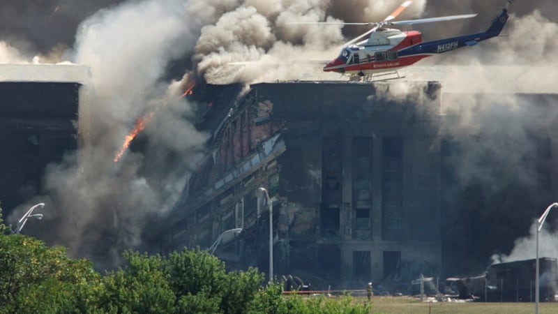 FILE PHOTO: A rescue helicopter surveys damage to the Pentagon as firefighters battle flames...
